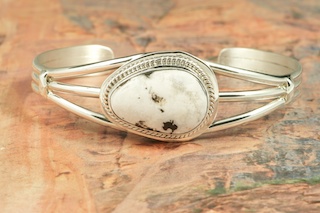 White Buffalo Turquoise set in heavy gauge Sterling Silver. This Beautiful Stone is formed from the minerals Calcite and Iron. It is mined near Tonopah Nevada. Created by Navajo Artist John Nelson. Signed by the artist.